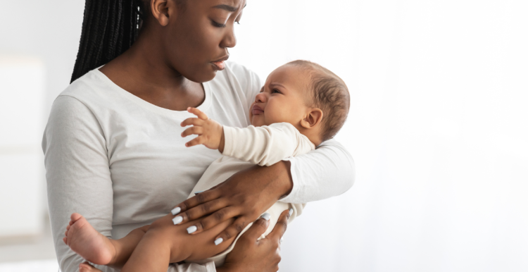 woman holding baby, both look distressed