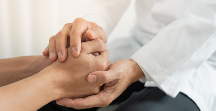 two people holding hands in a comforting way