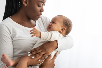 woman holding baby, both look distressed