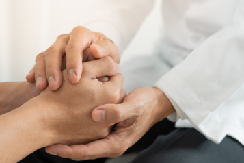 two people holding hands in a comforting way