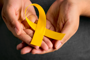 hands together holding a yellow ribbon