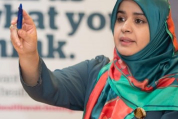 Annual Report Image. Woman raising her hand to ask a question. 