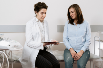 women talking on a hospital bed about pregnancy