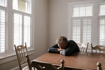 Man with head on table in distress